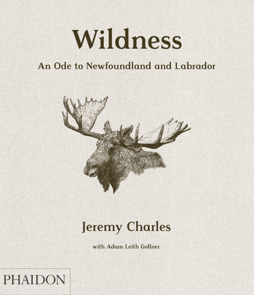 A beige fabric background featuring a brown-black moose head in the centre. The title "Wildness: An Ode to Newfoundland and Labrador" is printed above and the authors "Jeremy Charles with Adam Leith Gollner" printed below, the second name much smaller than the first. The publishing company's logo - Phaidon in all-caps in a rectangular box - is place in the bottom left corner.