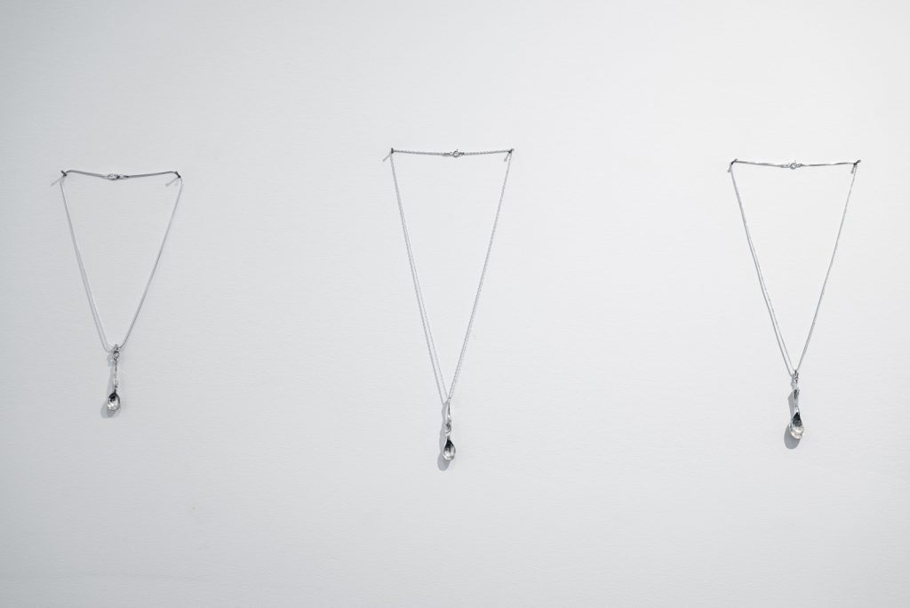A gallery wall with three pendants displayed. Titles in the caption.